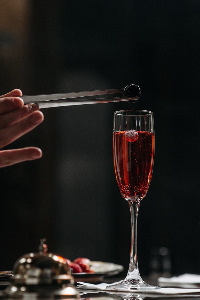 Close-up of a champagne flute with a blackberry garnish, symbolizing luxury and celebration.